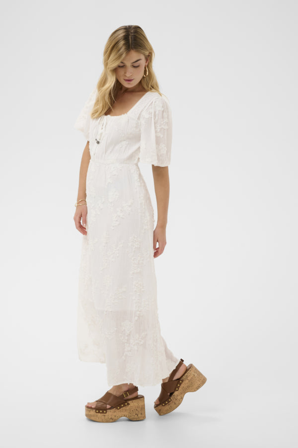 Cream Zammi Maxi Dress featuring a flowing design with a fitted waist and elegant textured floral embroidery, perfect for summer occasions.