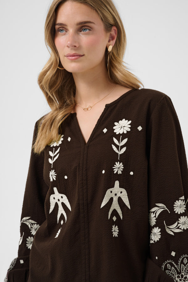 Cream Patulie Folk Embroidered Blouse with intricate colorful embroidery and long sleeves, displayed on a hanger.