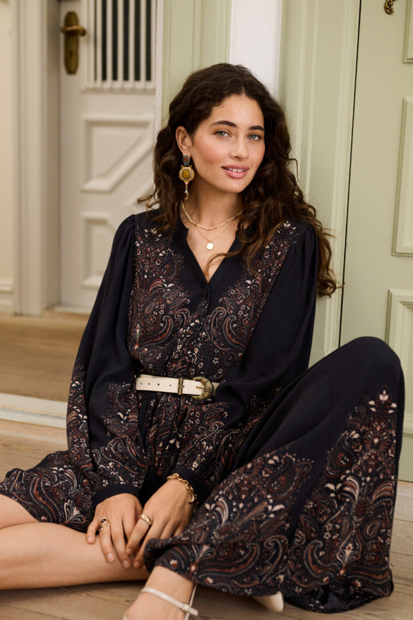 Cream Josia maxi dress displayed on a hanger, showcasing its flowing fabric and elegant design for women.