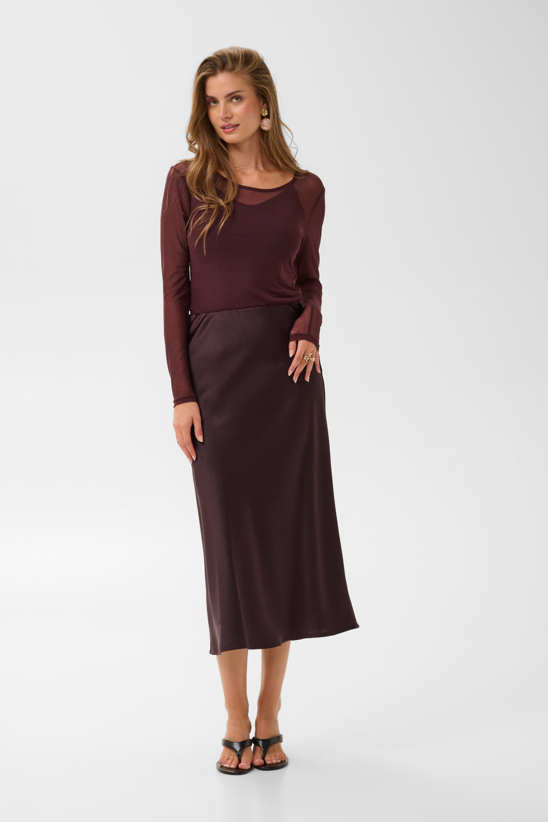 Cream Cocamia Midi Slip Skirt in soft fabric, featuring a sleek, flowy design and subtle slit for a stylish, comfortable look.