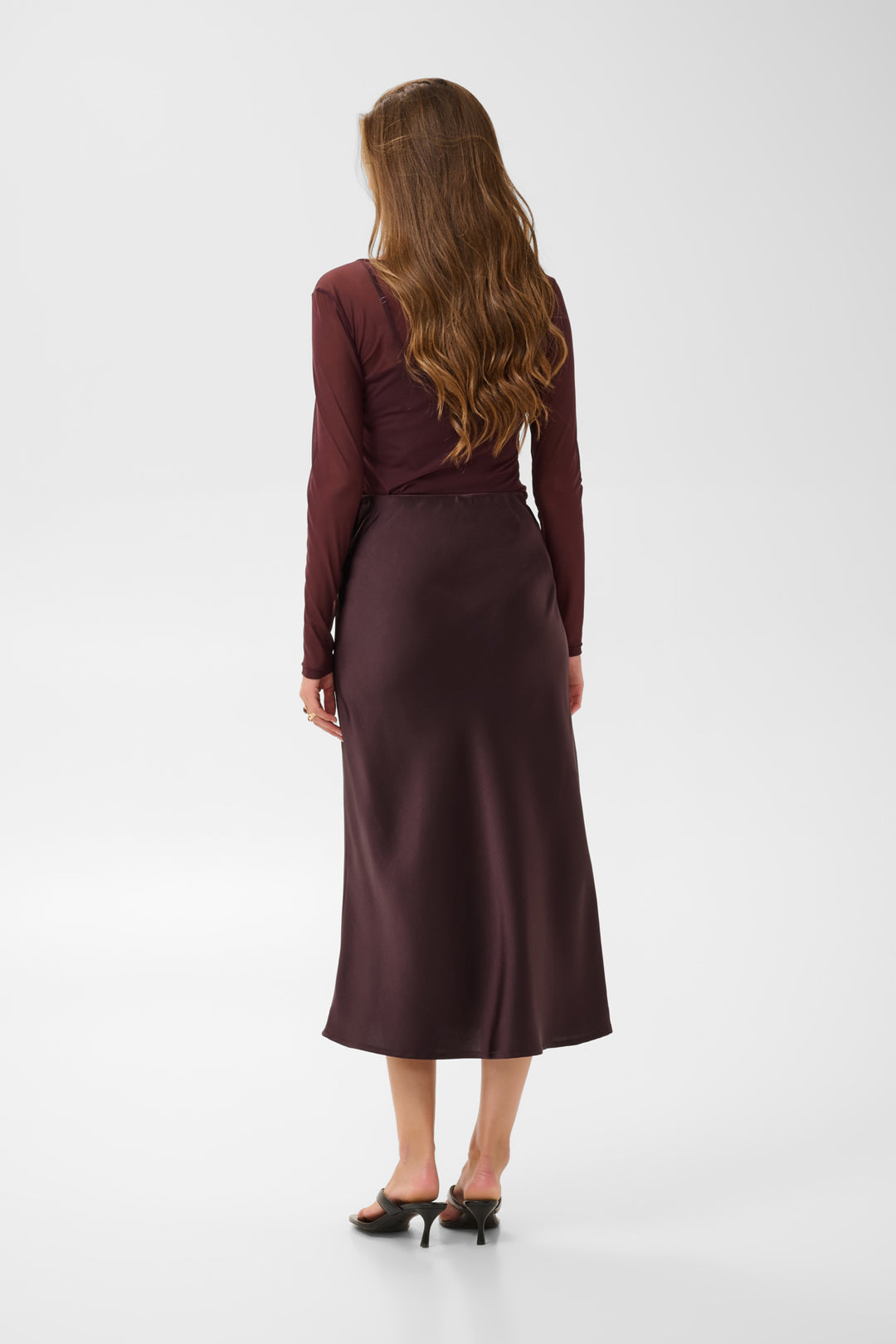 Cream Cocamia midi slip skirt in soft fabric, shown in a neutral color with a flowy, elegant silhouette.