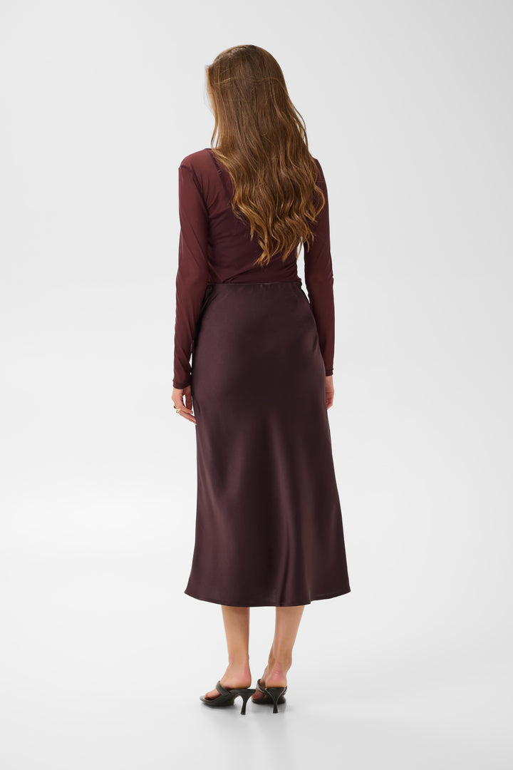 Cream Cocamia midi slip skirt in soft fabric, shown in a neutral color with a flowy, elegant silhouette.