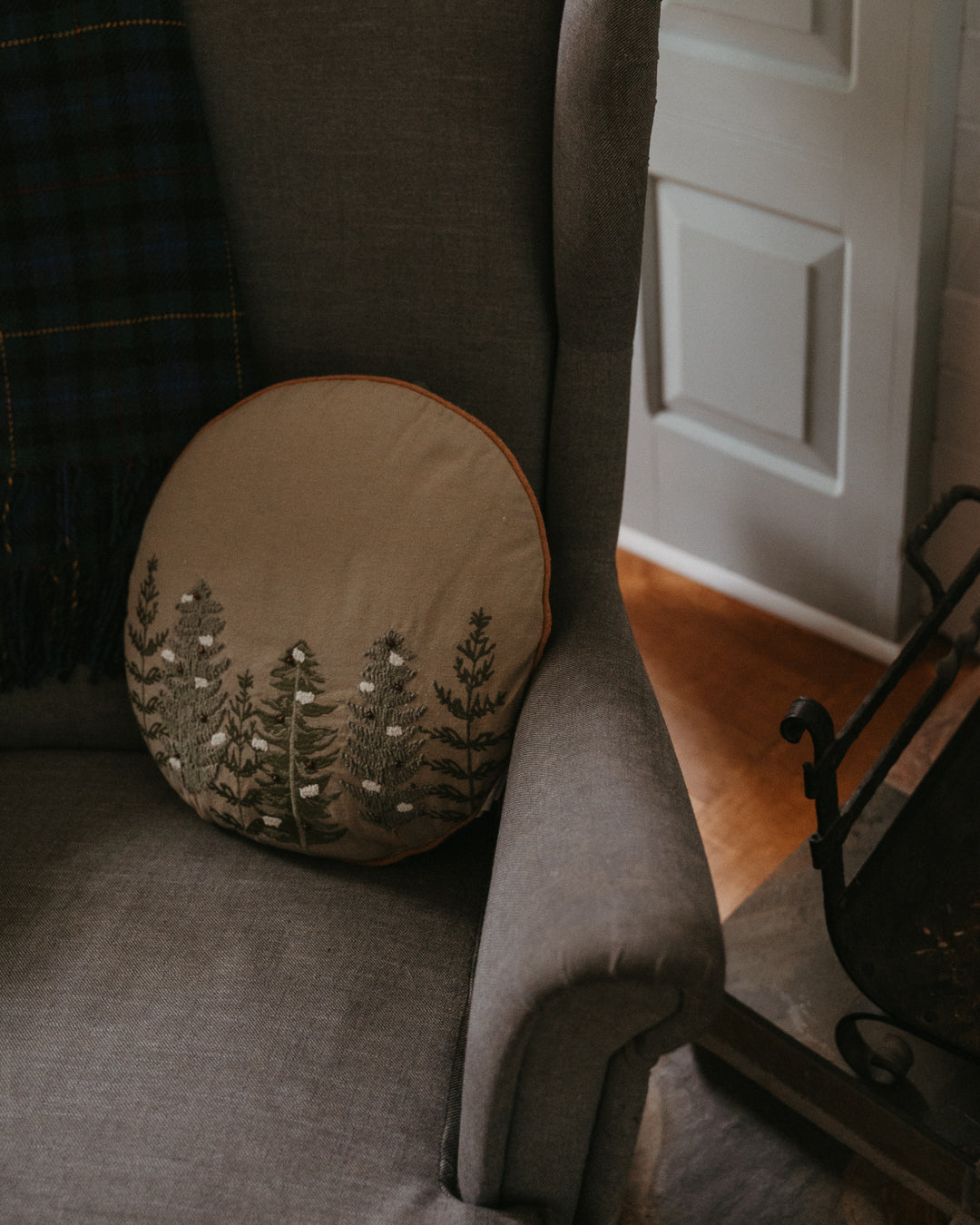 Indaba Alpine Trees round throw pillow featuring a nature-inspired design with alpine trees, soft fabric, and cozy style.