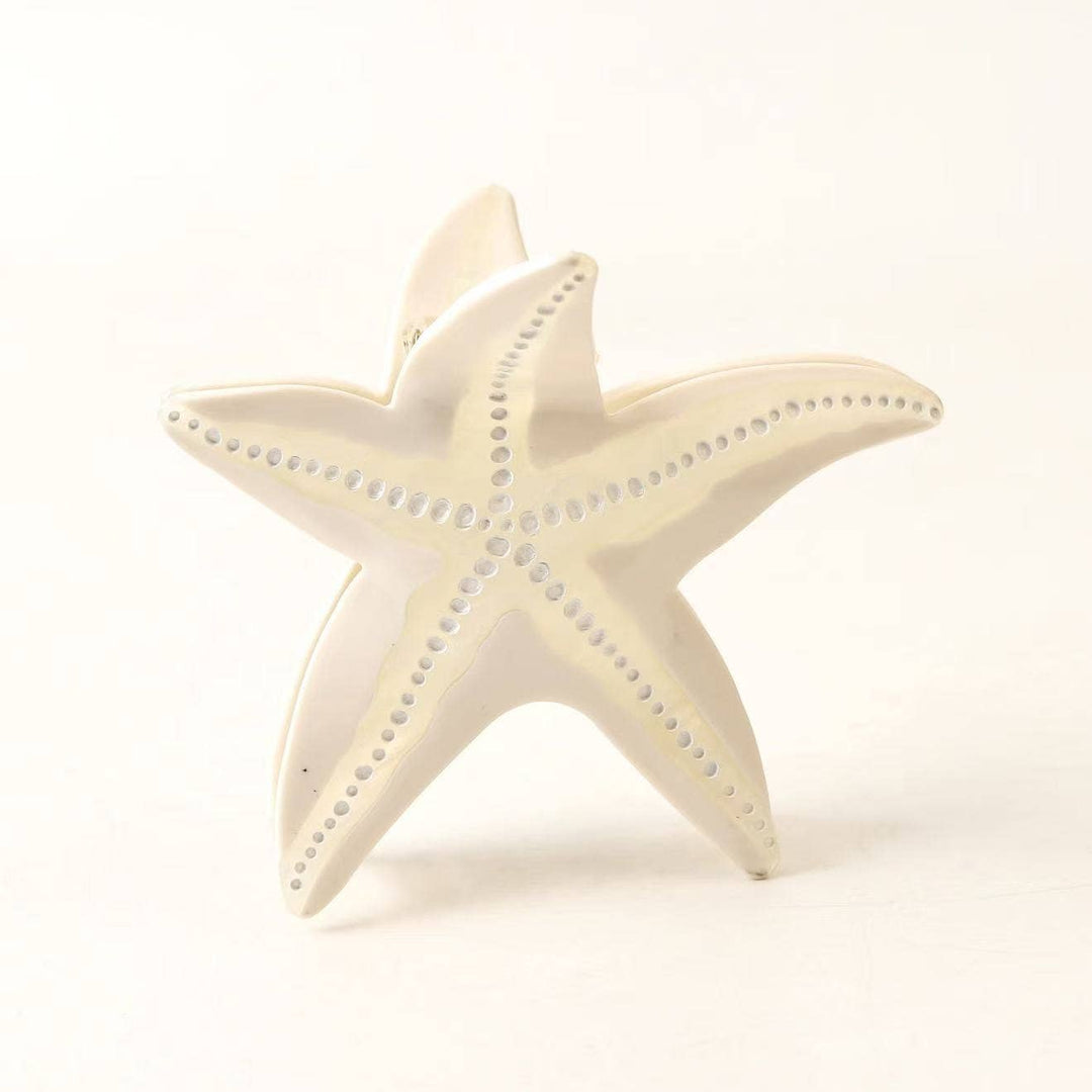 LadyJuneAccessories starfish-shaped claw clip holding hair, featuring a detailed starfish design and durable plastic construction.