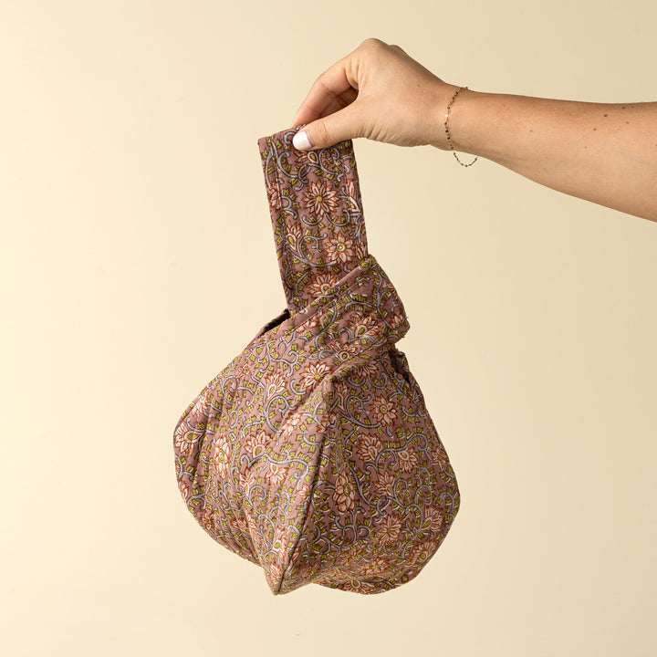 Indaba floral block print vanity pouch with colorful floral design, compact size, and knot closure for travel and organization.