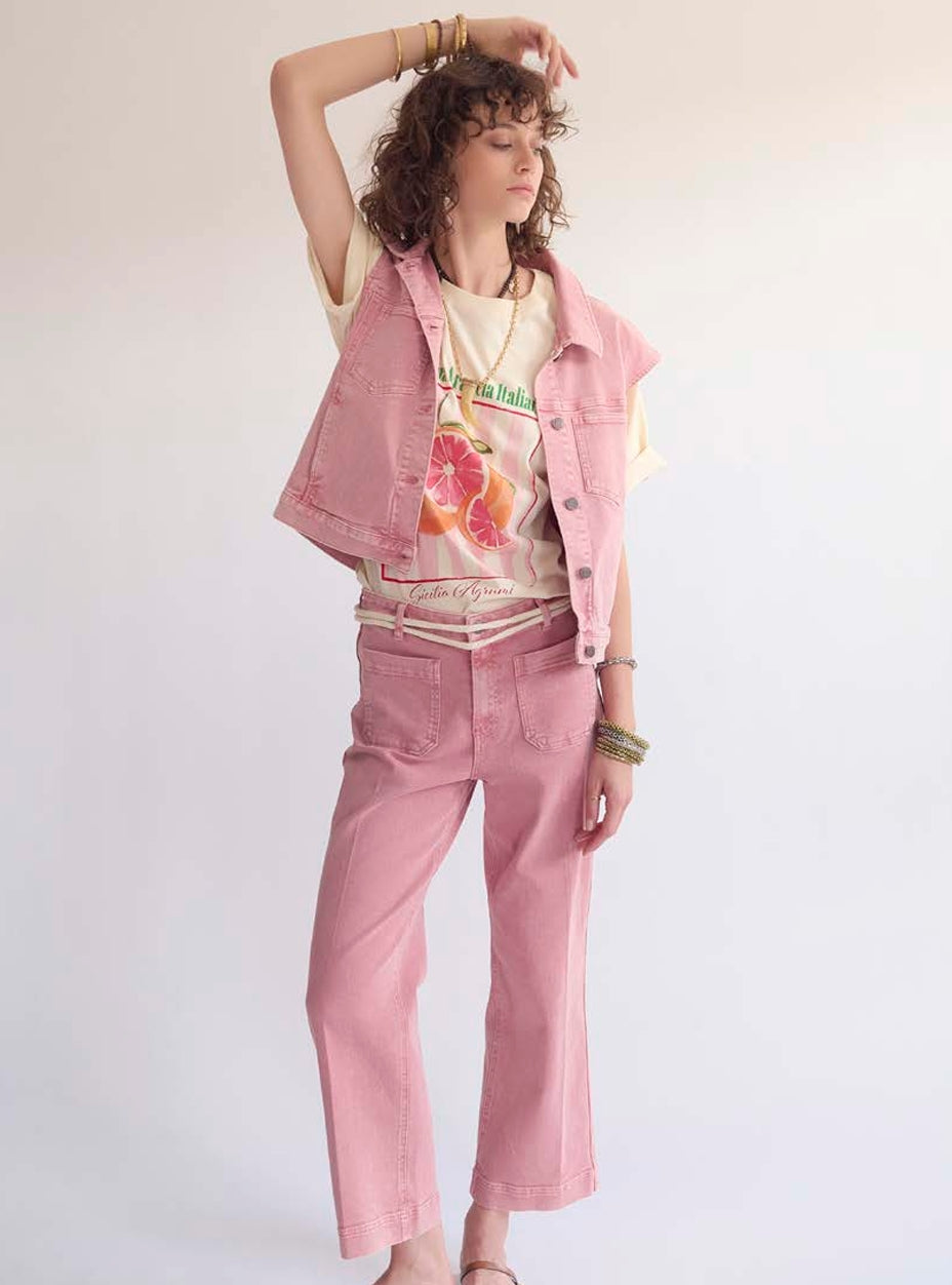 Person wearing a pink vest, pink pants, and a graphic t-shirt on a white background