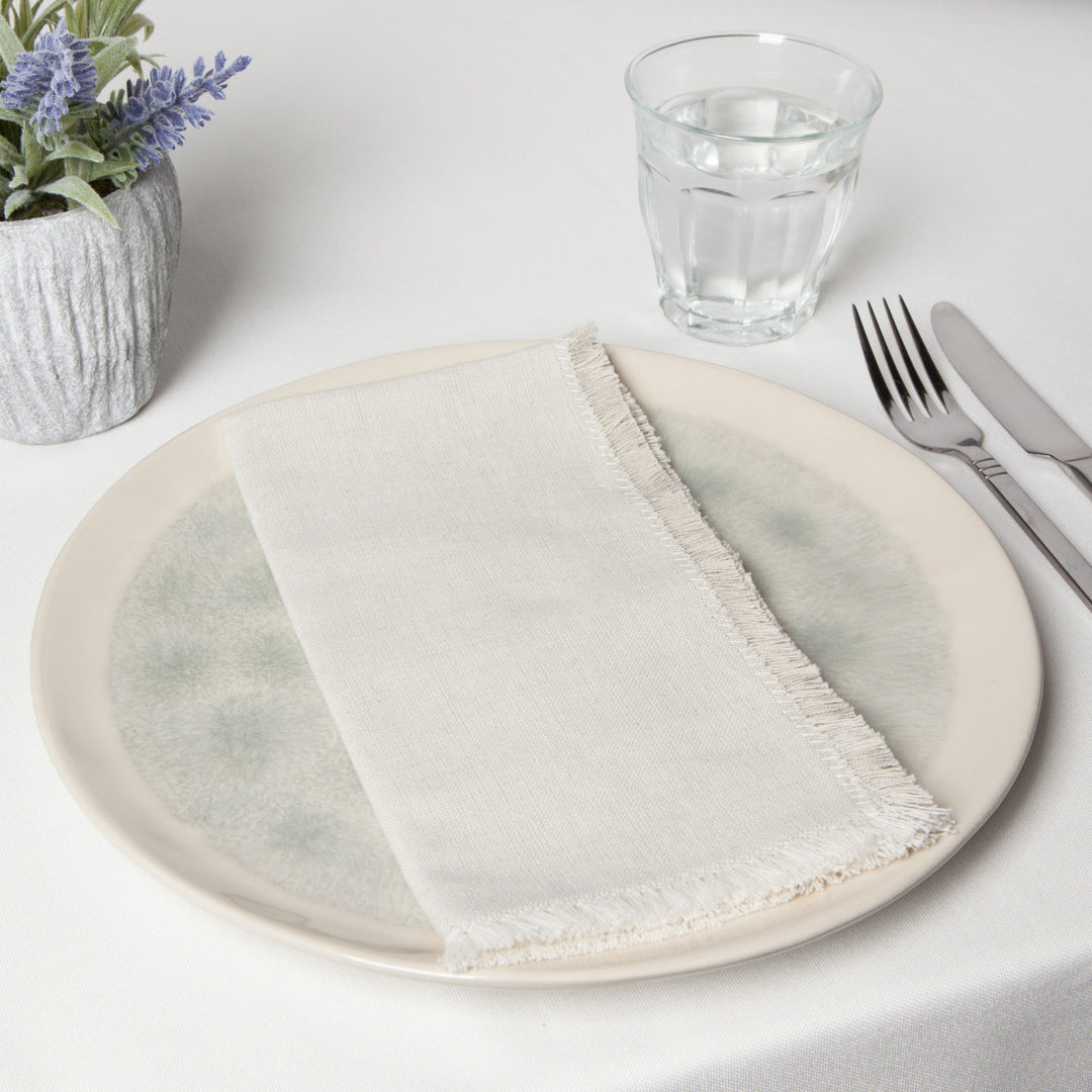 Set of Danica chambray cotton table napkins folded neatly, showcasing their soft beige fabric and classic design for dining decor.