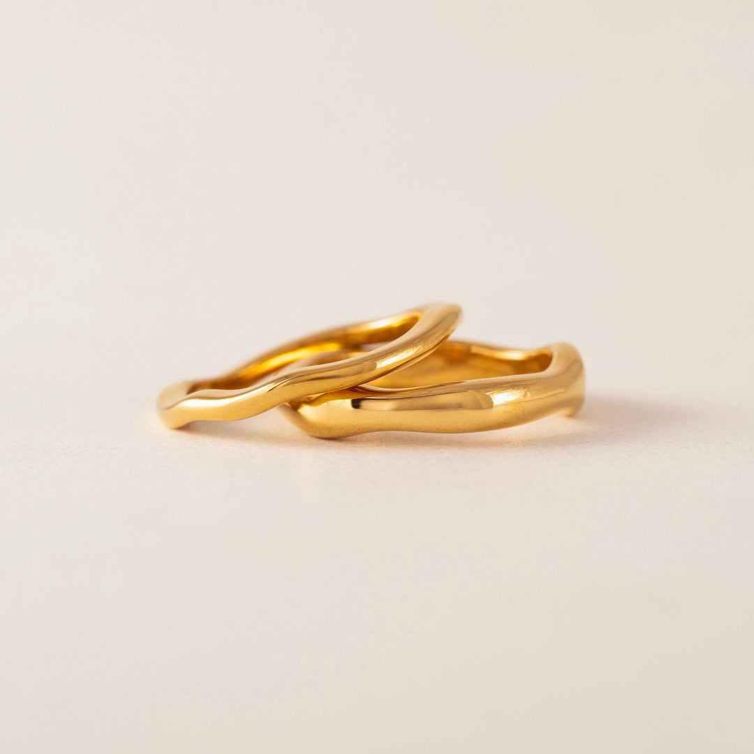 Lover's Tempo coral ring set featuring two gold bands with wave design for stylish jewelry wear.