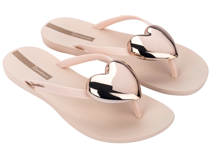 Beige flip-flops with metallic heart-shaped straps on a white background