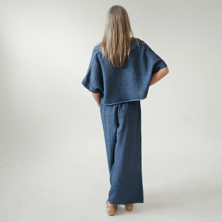 Pokoloko crinkle crop top with short sleeves, featuring a textured, lightweight fabric and a relaxed fit.