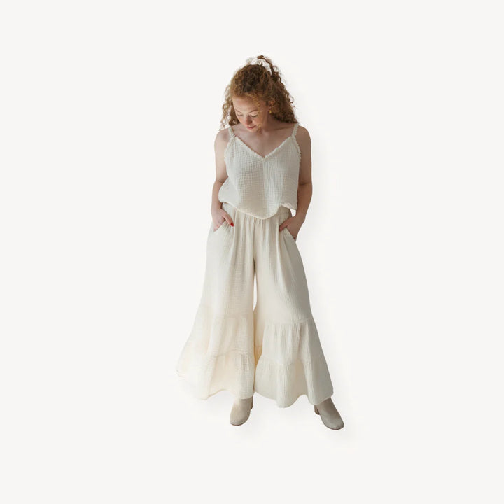 Crinkle cotton ruffled pants by Pokoloko featuring a relaxed fit, ruffle tiers on a flared leg, and lightweight, breathable fabric.