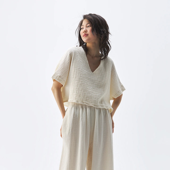 Pokoloko crinkle crop top featuring short sleeves and a textured, crinkled fabric in a stylish, casual design.