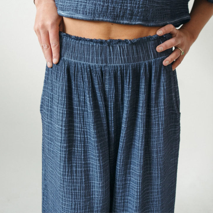 Light blue crinkle palazzo pants by Pokoloko featuring wide-leg denim-style design, comfortable loungewear for relaxed style.
