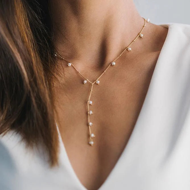 Gold lariat necklace with dot pearl accents from Lover's Tempo, featuring a delicate chain and elegant pearl details.