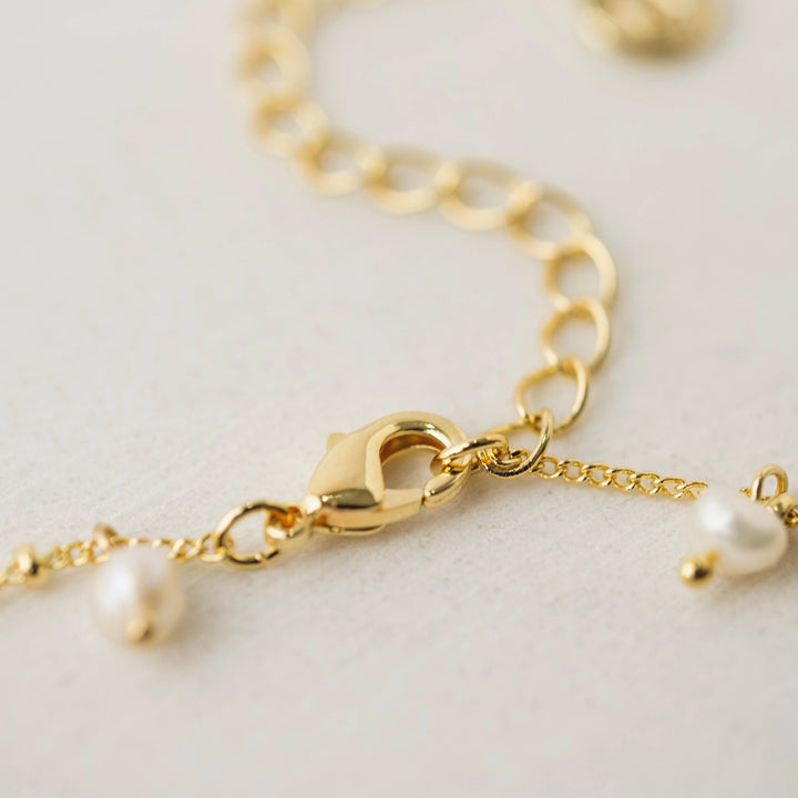 Lover's Tempo Dot Pearl Gold Lariat Necklace with a sleek chain and elegant pearl accents, showcasing a modern jewelry design.