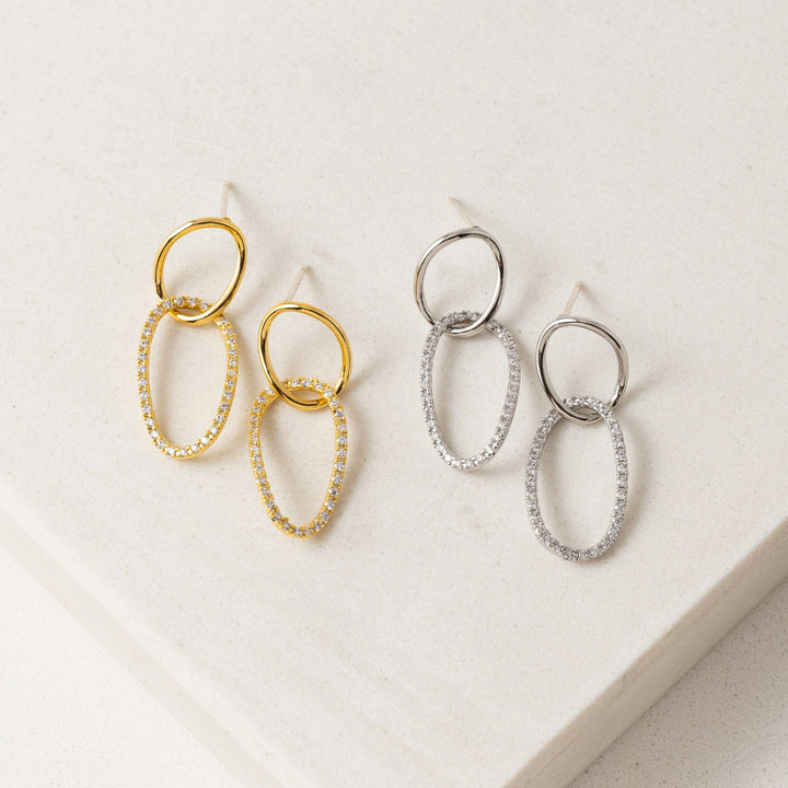 Pair of gold and silver hoop earrings on a light background