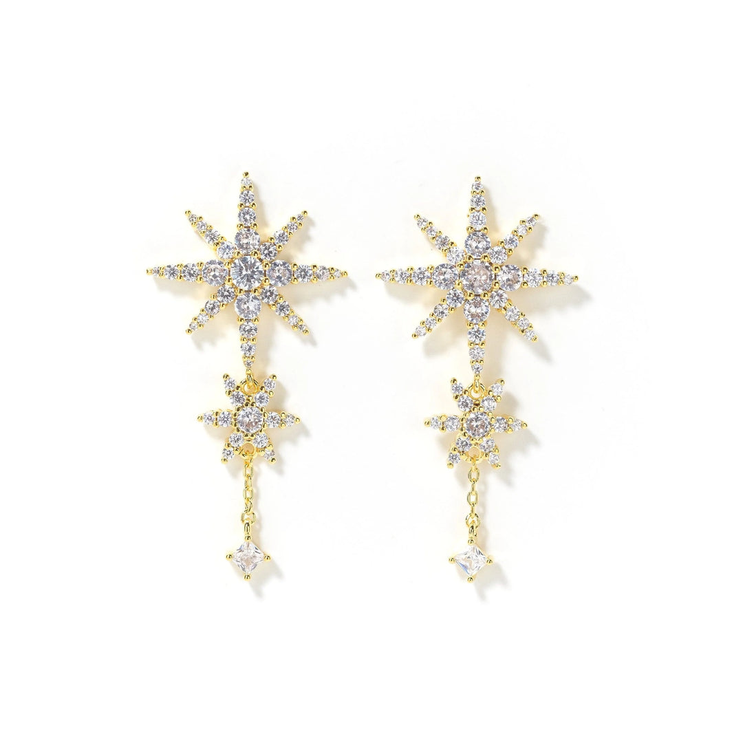 Gold star-shaped earrings with clear stones on a white background