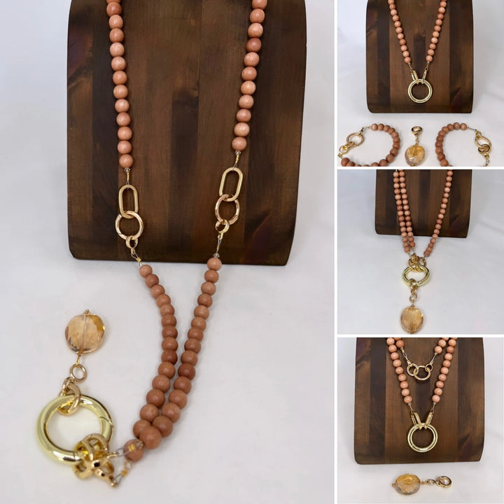 Necklace with wood beads and gold accents on a wooden stand.