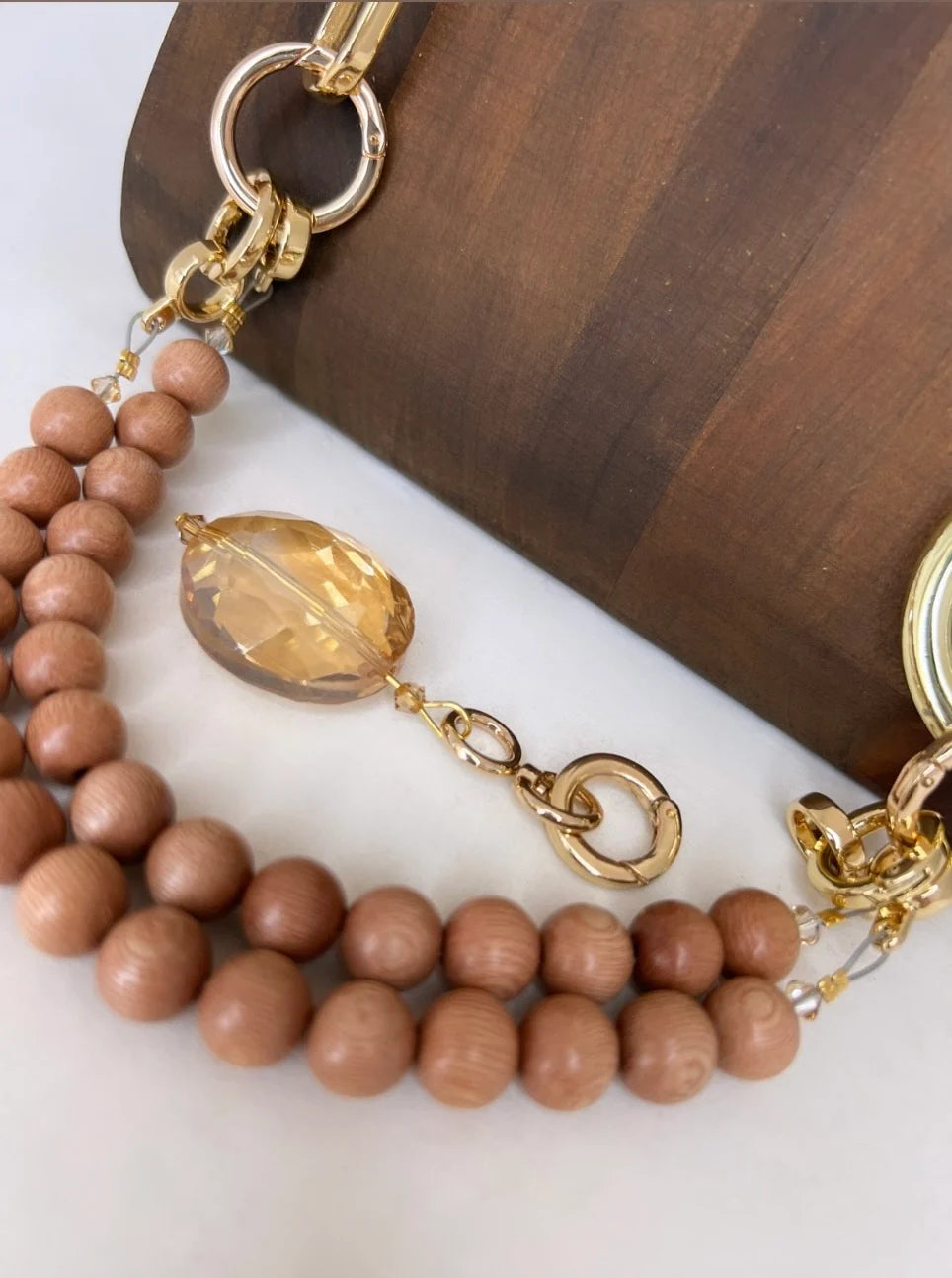 Necklace with wooden beads and gold accents on a wooden surface
