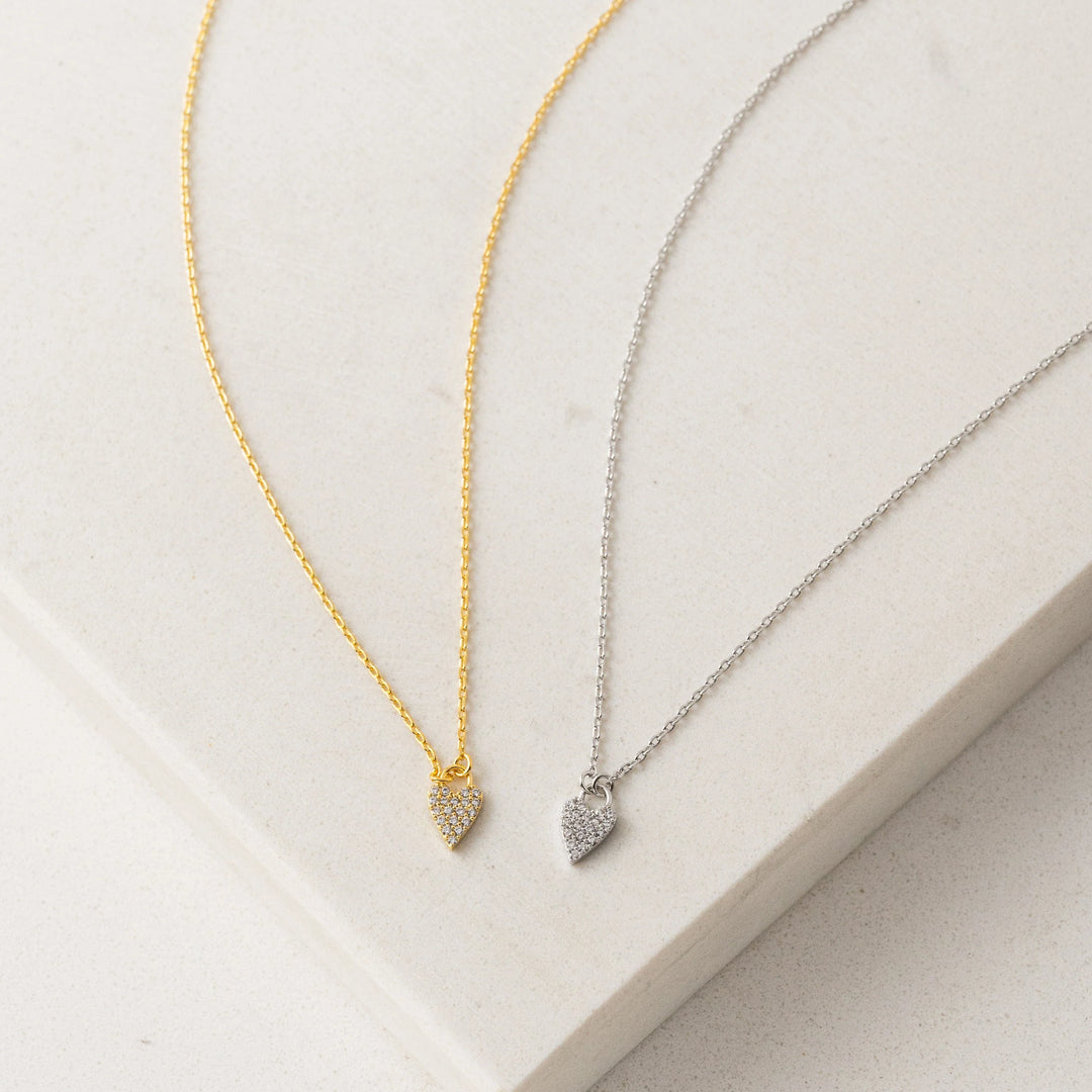 Two necklaces with heart-shaped pendants on a light background