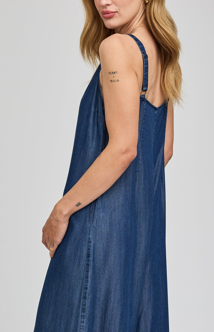 Gentle Fawn Cambry denim romper jumpsuit with adjustable straps, side pockets, and a relaxed fit, styled with casual accessories.