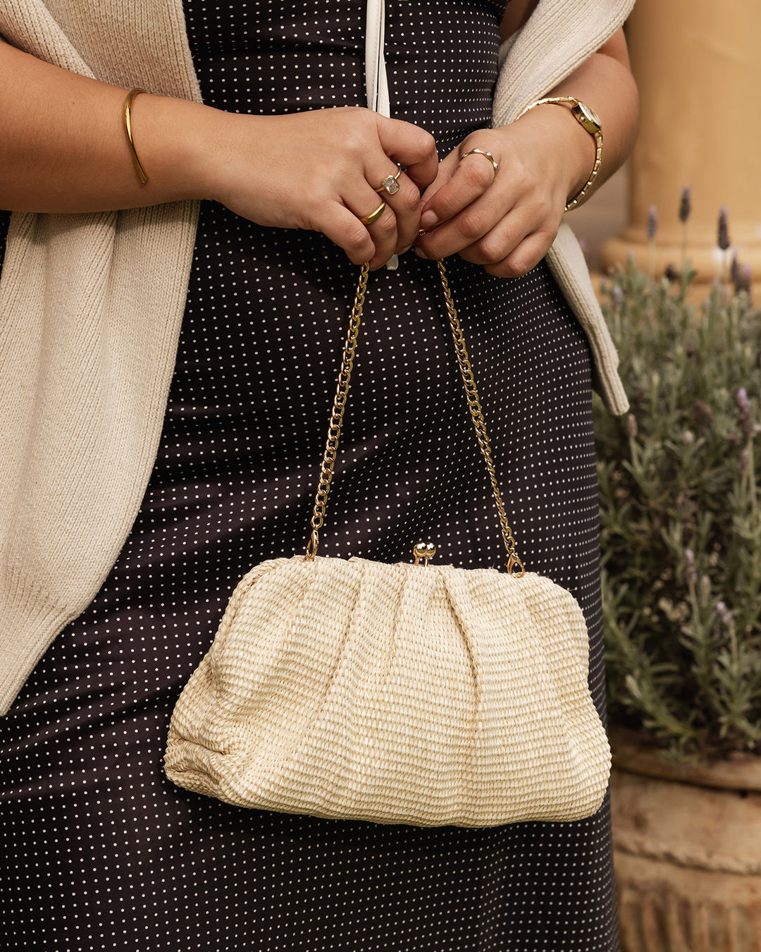 Louenhide Goldie Raffia Clutch bag with woven raffia exterior and gold-tone accents, perfect for casual or evening wear.