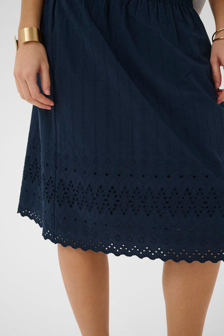 Cream Jana cotton skirt displayed on a model, showcasing its stylish knee length design and lightweight fabric for a casual, comfortable look.