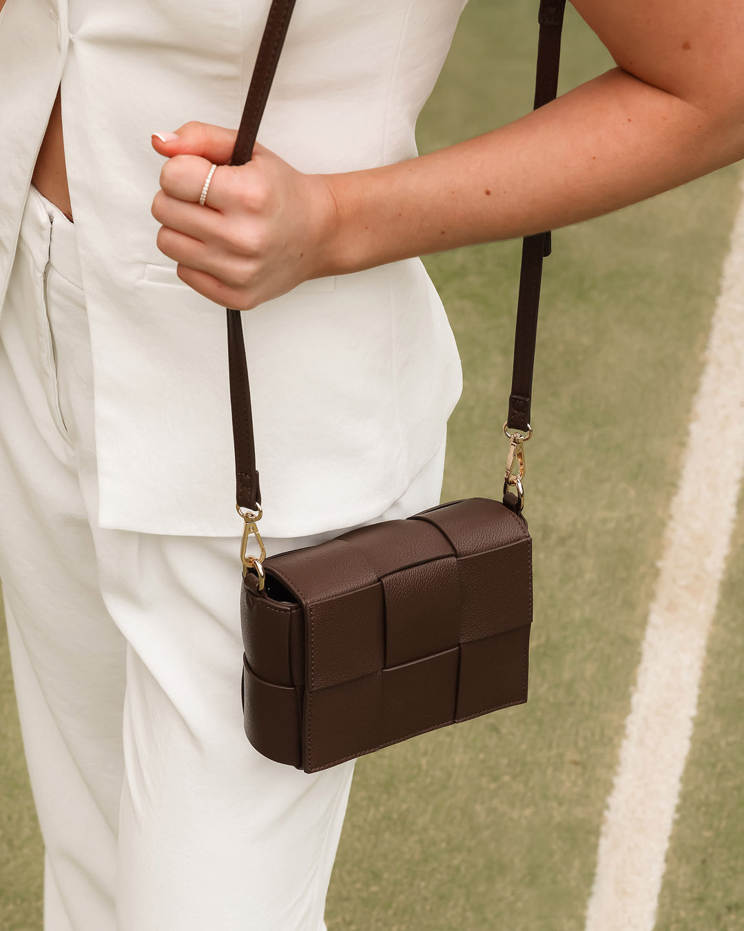 Louenhide Josephine Crossbody Bag featuring a sleek woven design, adjustable chain strap, and stylish exterior in brown tones.