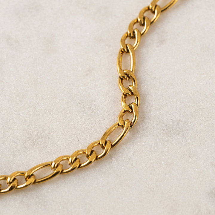 Gold chain on a light beige background