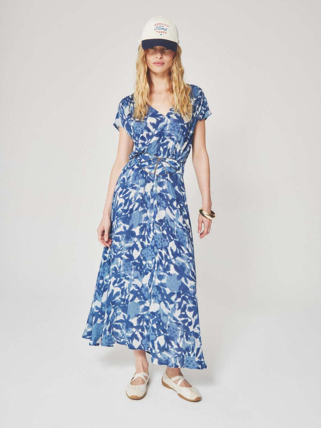 Woman wearing a blue and white floral patterned midi dress with a summer style for semi floral and event occasions.