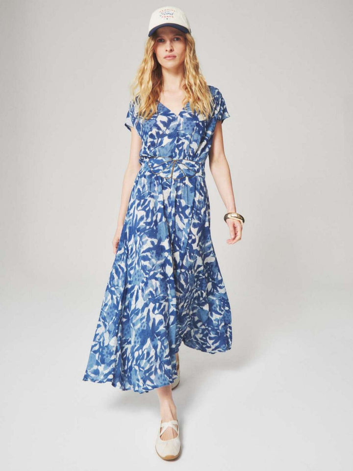 Woman wearing a blue and white floral patterned midi dress with a summer style for semi floral and event occasions.