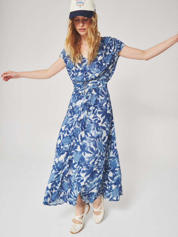 Woman wearing a blue and white floral patterned midi dress with a summer style for semi floral and event occasions.