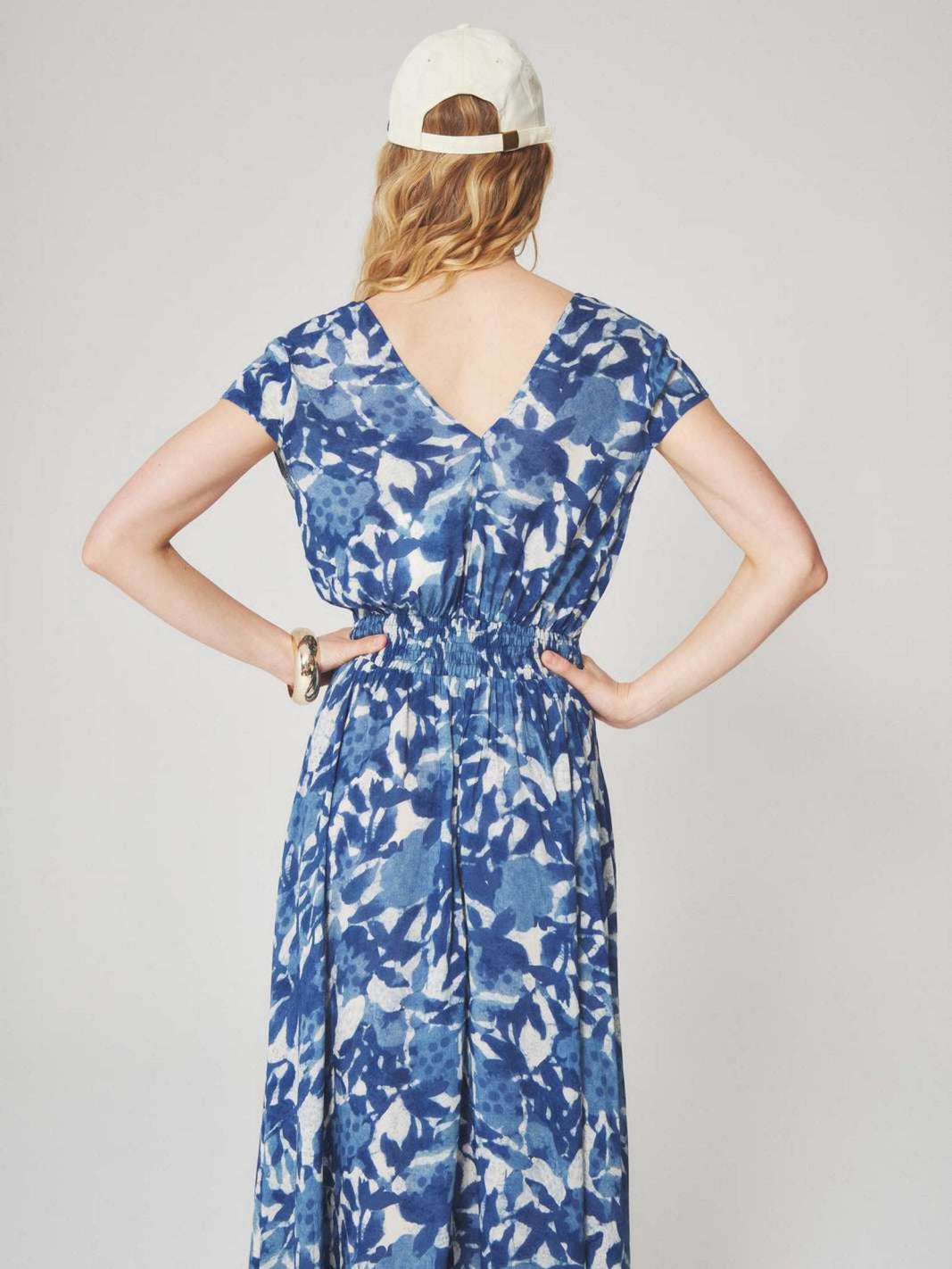 Woman wearing a blue and white floral patterned midi dress with a summer style for semi floral and event occasions.