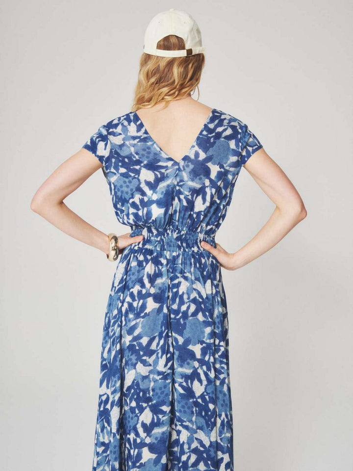 Woman wearing a blue and white floral patterned midi dress with a summer style for semi floral and event occasions.
