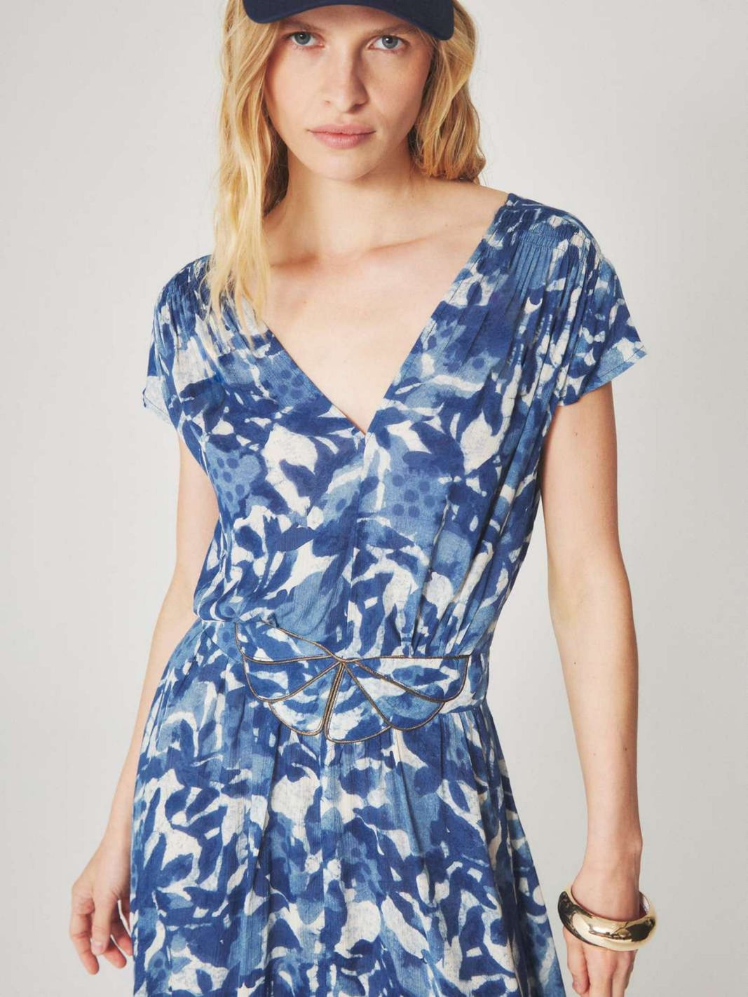 Woman wearing a blue and white floral patterned midi dress with a summer style for semi floral and event occasions.