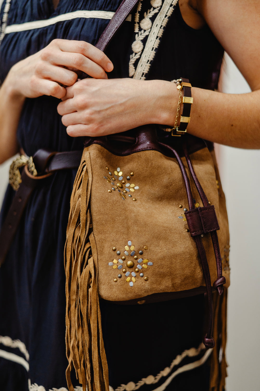 MKT Studio Bayanne leather bag featuring a bucket design, studded design, and natural suede leather texture and fringe detail for stylish everyday use.