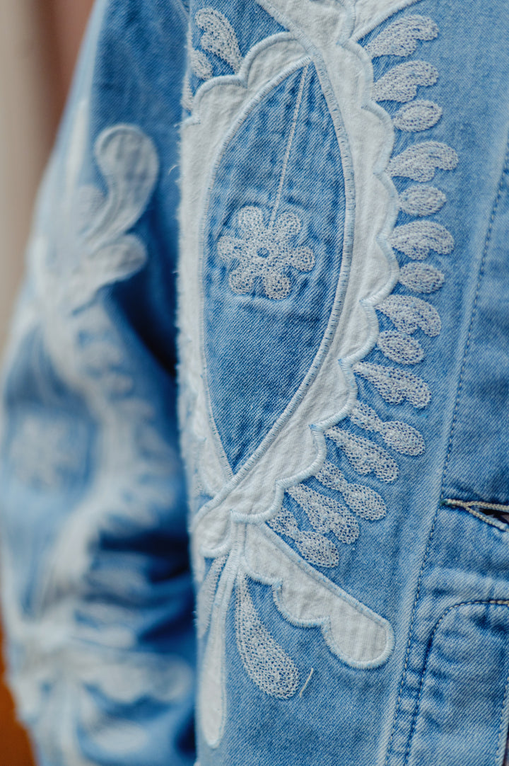 Desigual Paloma embroidered denim jacket with modern bold floral embroidery, classic collar, and button closure.