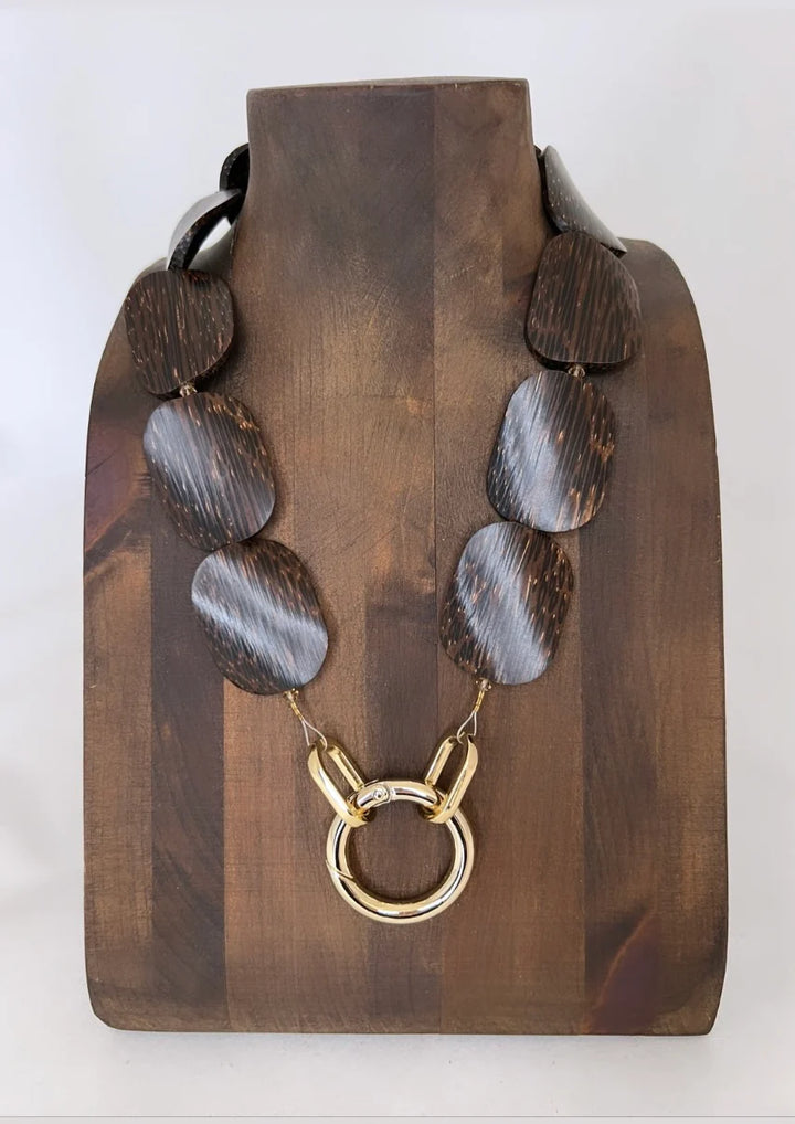 Lofttan Nay Palm Wood Necklace featuring a natural wooden pendant on a cord, showcasing earthy tones and handcrafted design.