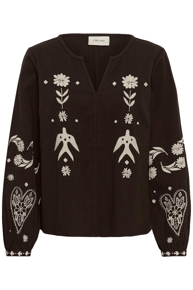 Cream Patulie folk embroidered blouse with colorful floral and geometric embroidery on lightweight fabric.