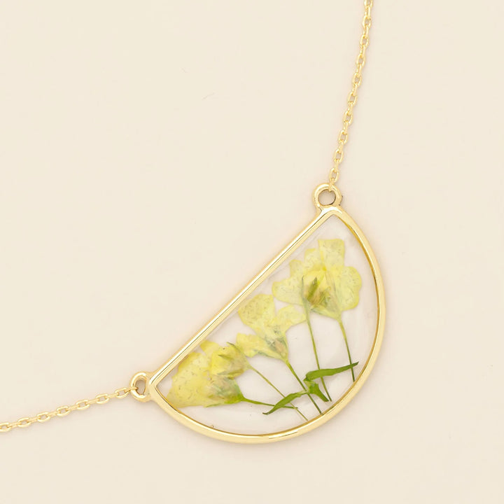 Scout pressed flower necklace featuring a delicate round pendant with preserved colorful flowers on a fine chain.