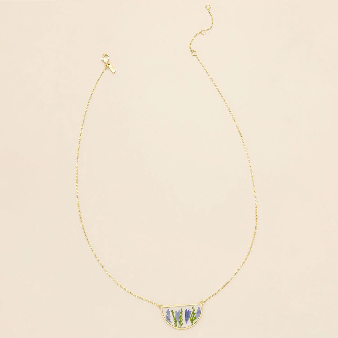 Scout pressed flower necklace featuring a delicate circle pendant with preserved colorful flowers on a gold chain.