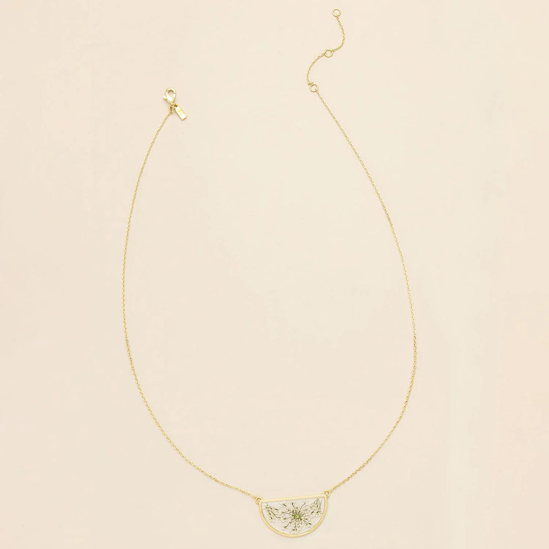 Pressed flower necklace by Scout featuring a delicate round pendant with preserved floral design on a gold chain.