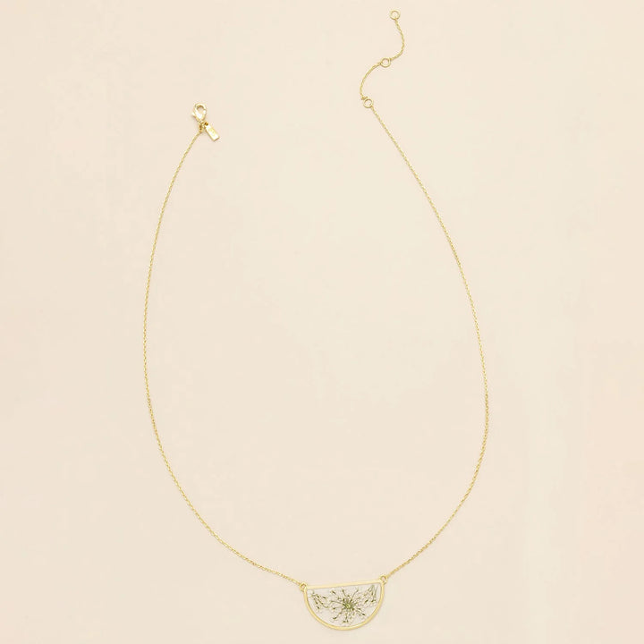 Pressed flower necklace by Scout featuring a delicate round pendant with preserved floral design on a gold chain.