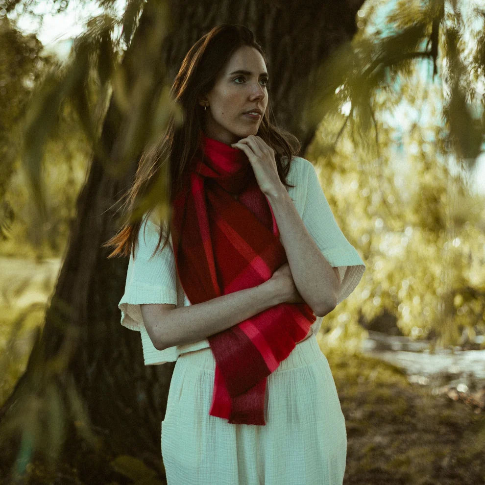Woman wearing an  alpaca wool scarf red scarf in a forest setting