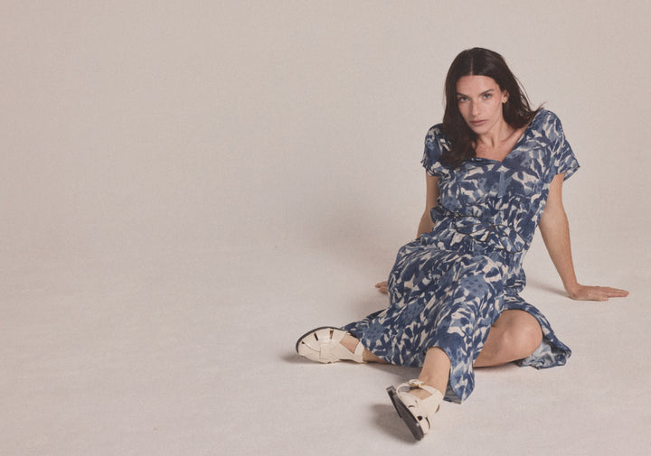 Woman wearing a blue and white floral patterned midi dress with a summer style for semi floral and event occasions.