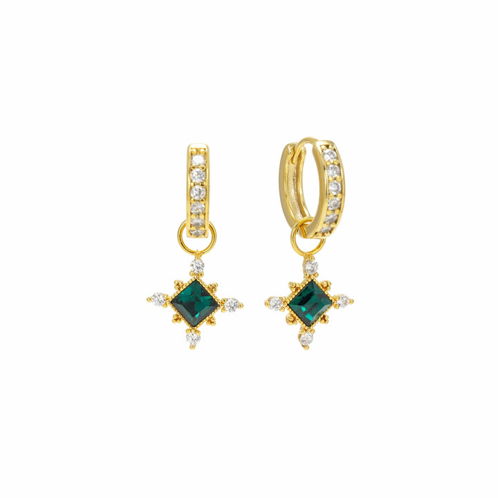 Gold hoop earrings with green gemstones on a white background