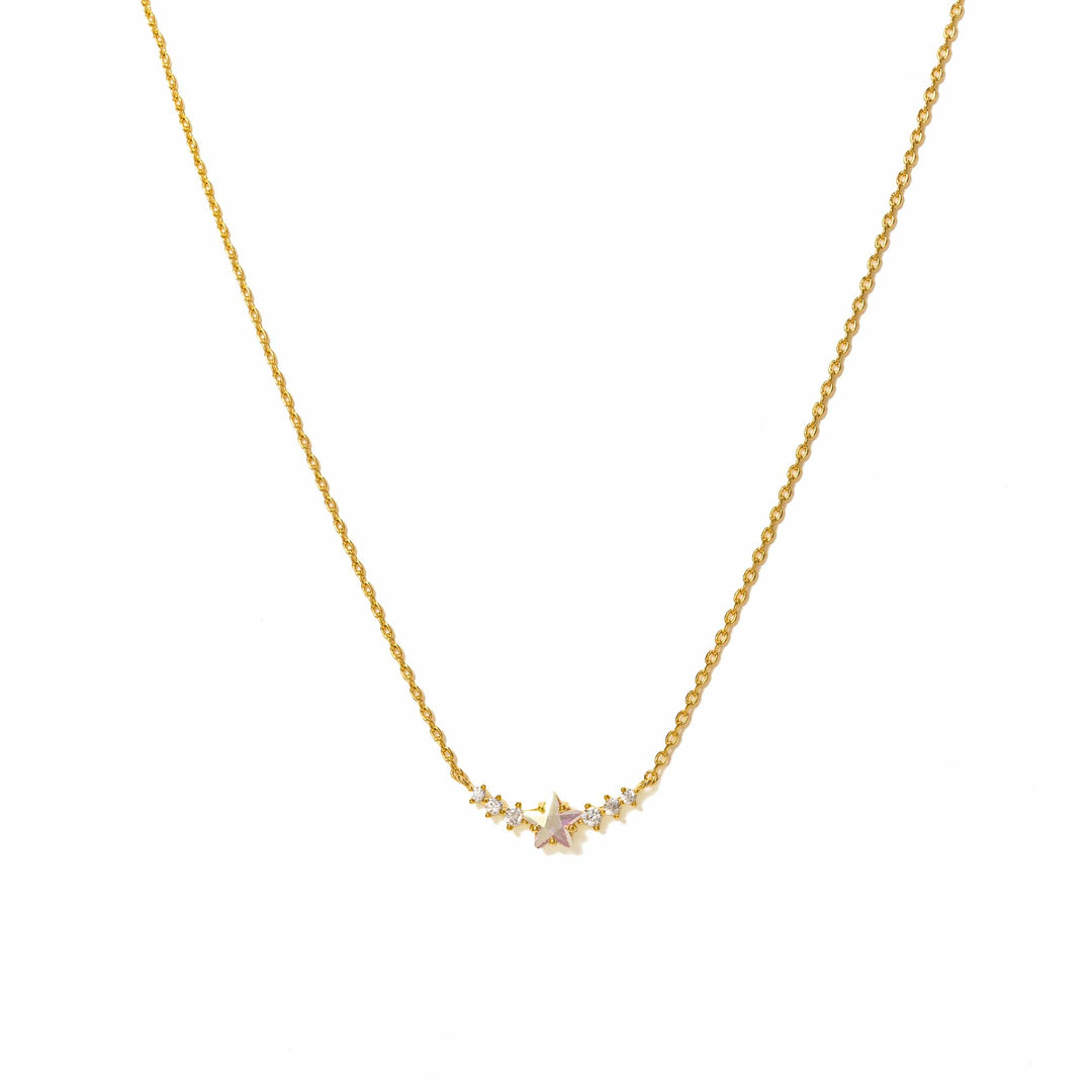 Gold necklace with a small pink gemstone on a white background