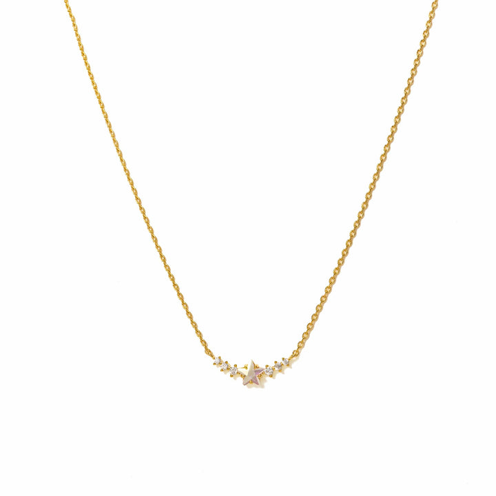 Gold necklace with a small pink gemstone on a white background