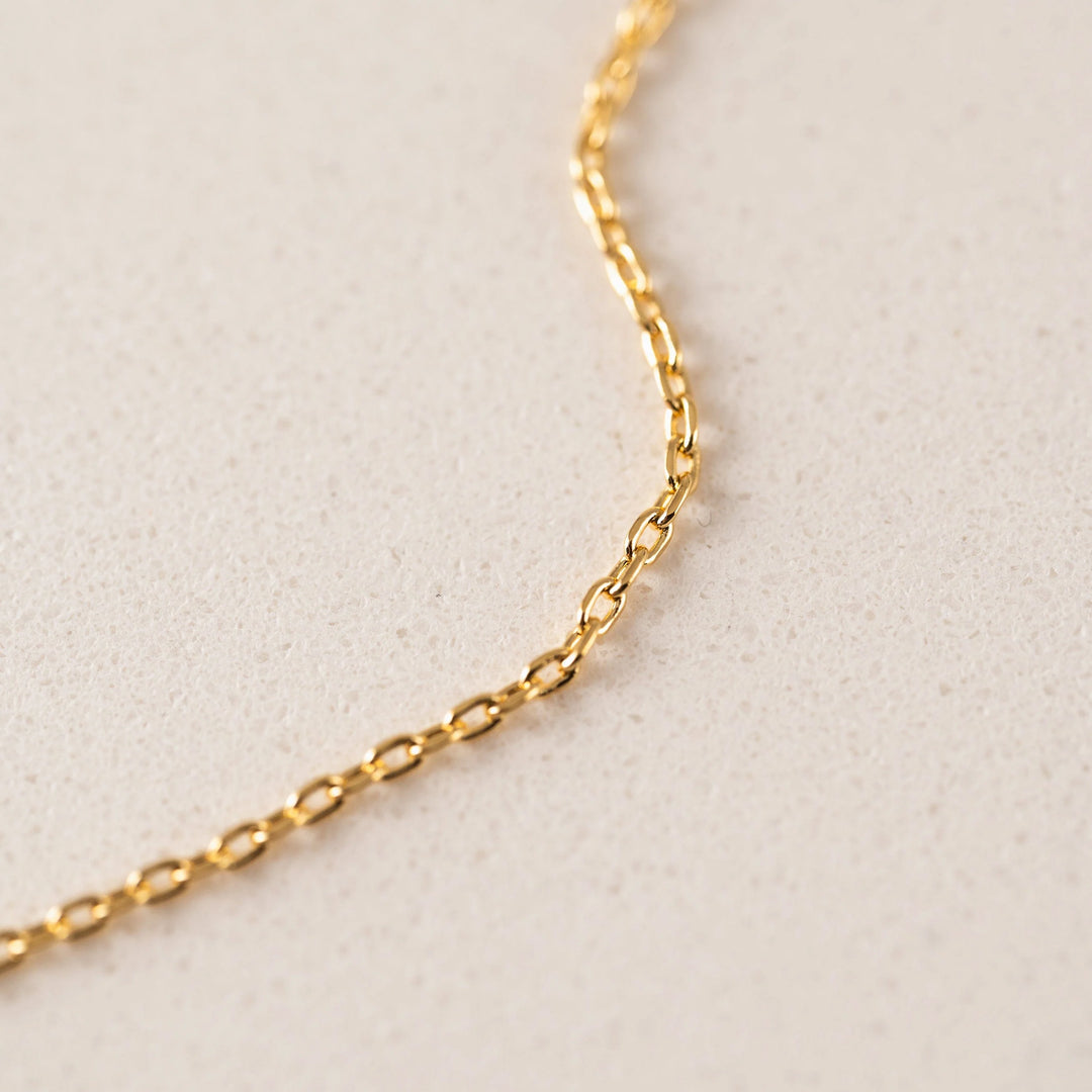 Gold chain on a light beige background