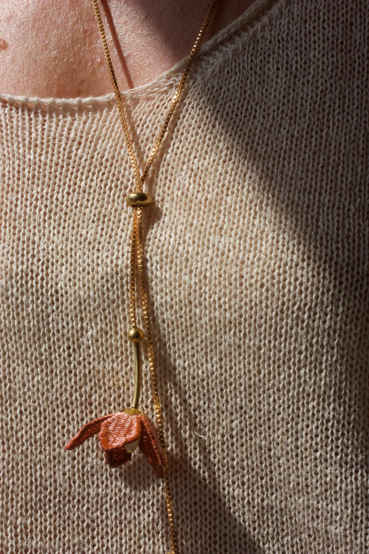 Tahitian Gardenia flower necklace by Ilk Jewelry featuring a delicate floral pendant in vintage lace on a gold chain.
